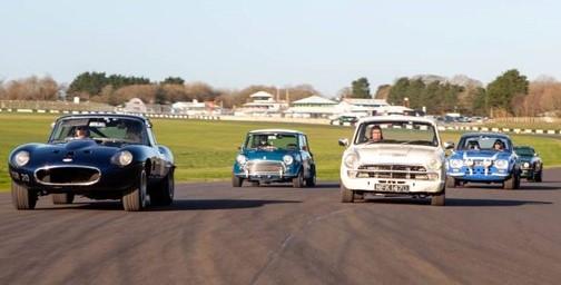An E-type, Mini, Lotus Cortina and Escort side by side on a circuit