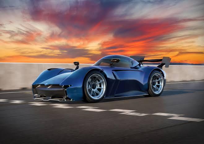 A modern blue hypercar on a circuit at sunset